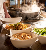 Stir fry ingredients alongside a wok at the Islands Dining Room at Loews Royal Pacific Resort.